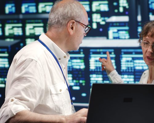 Older colleagues looking around innovative server farm, preparing to start comission on malfunctioning high tech establishment hardware rows in order to ensure perfect operations