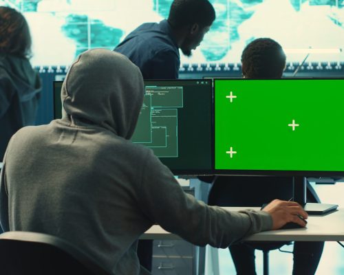 Professional team of governmental hackers conducting cyber surveillance, looks at isolated copy space screen. Expert examines cybersecurity measures and online security in high tech agency. Camera A.