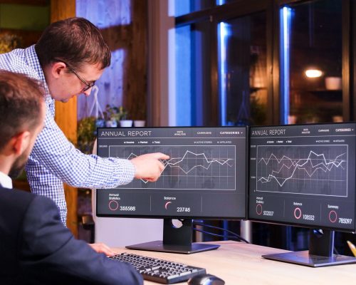 Two colleagues working late at the office. Blue light and night view